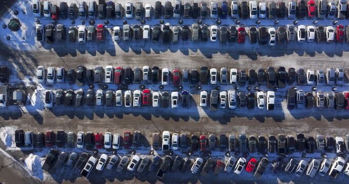 Top-down aerial view of rows of cars in a parking lot during winter, Calgary, Alberta, Canada.