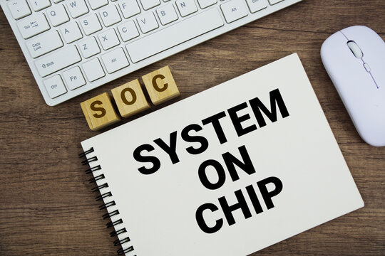SOC System On Chip message with keyboard and optical mouse on wooden background