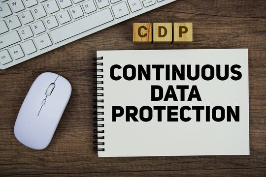 CDP Continuous Data Protection message with keyboard and optical mouse on wooden background