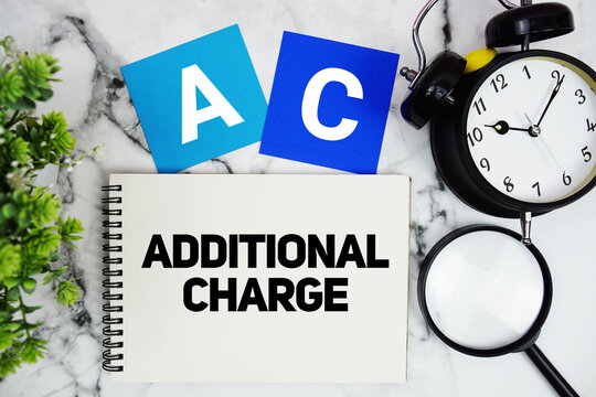 AC Additional Charge text written on notepad with alarm clock and magnifying glass on marble background