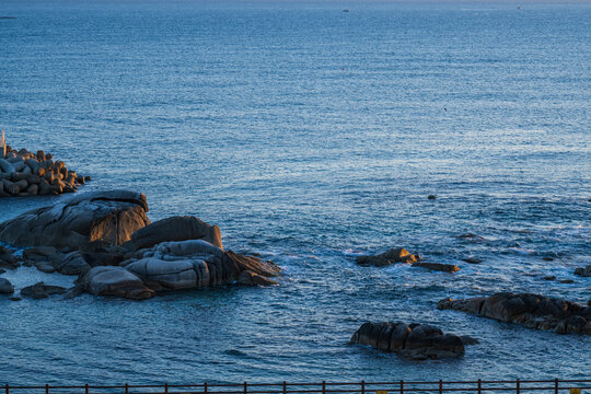 Scenic view of rocky coastline and blue ocean waters under morning sunlight in Yangyang county in South Korea.