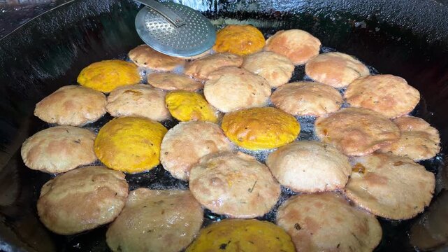 Indian street food puri or bedai frying in hot oil large wok 4k video footage