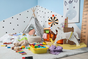 Childhood development and play, messy nursery room with toys and teepee tent for creative learning and early education in a modern home interior © Pixel-Shot