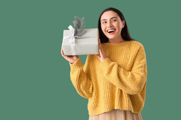 Fototapeta premium Holiday gift giving and seasonal celebration, happy woman holding a present with a pine branch decoration for winter holidays and festive shopping