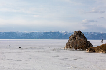 Panoramic view of Shamanka Rock standing on the frozen surface of Lake Baikal near Khuzhir village in Irkutsk Oblast, Russia, showing snowy ice plains and distant mountain ridges © TravelFlow
