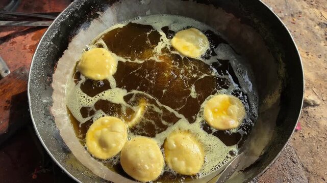 Deep frying indian puri bedai or kachori bread in hot oil 4k video footage