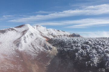 High angle view of volcanic crater with frozen slopes, rugged volcanic rock and blue sky at Avachinsky Volcano in Kamchatka Krai, Russia offering wilderness mountain scenery © TravelFlow