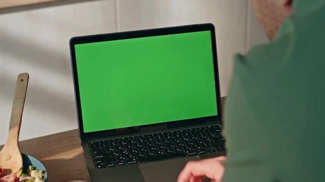 greenscreen of man working on laptop computer