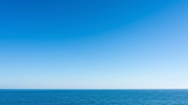 Clear Blue Sky Over Expansive Ocean Horizon During Daylight Hours with Gentle Waves and Tranquil Atmosphere