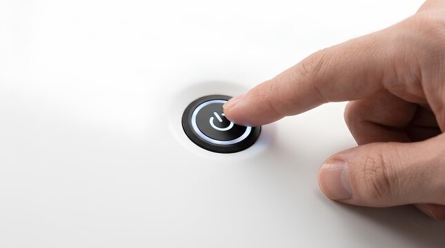 Close up of a finger pressing a power button on a white surface.