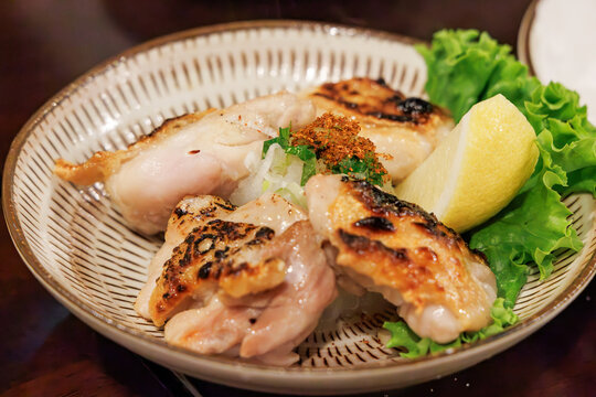 レモンと薬味が添えられた地鶏の炭火焼き