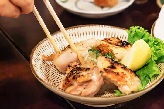 レモンと薬味が添えられた地鶏の炭火焼き