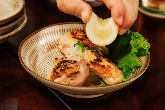 レモンと薬味が添えられた地鶏の炭火焼き