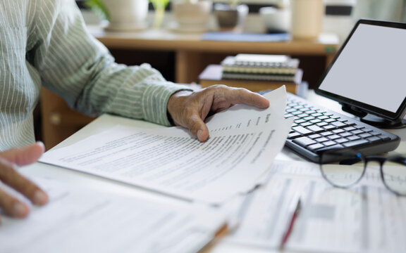 close up shot, businessman, professional lawyer working with computer reading and checking business documents and contract before giving advice to customers