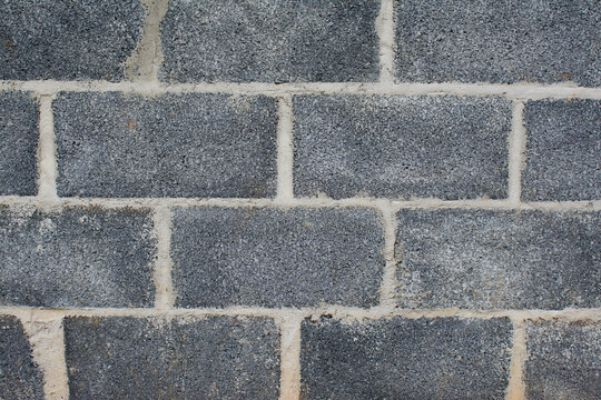 Gray concrete block wall with rough texture and light mortar joints.