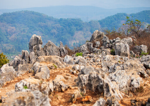 Scenic view of ancient karst stone rock formations at Stone Garden geotourism site with distant hills in Padalarang, West Bandung, West Java, Indonesia. Detailed view of ancient limestone karst rocks.