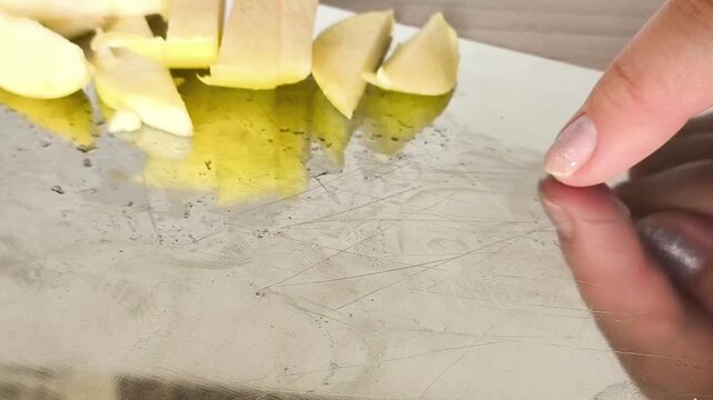 Scratched stainless steel cutting board with visible knife marks, representing kitchen wear, repeated food preparation and long-term use.