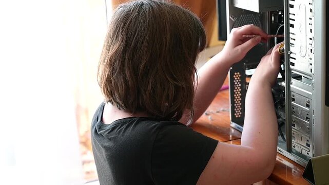 Teenage girl cleaning systemic unit of a desktop computer slow motion