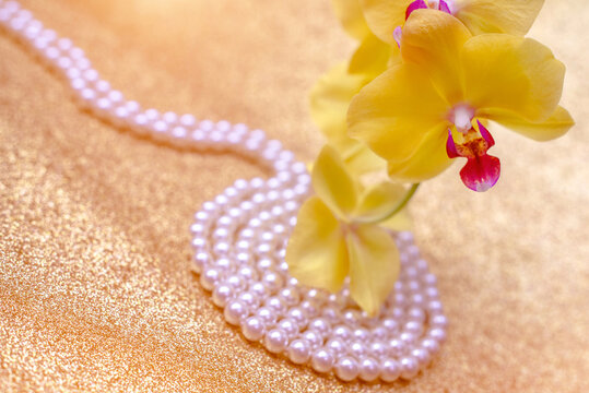 A branch of yellow orchids on a shiny gold background
