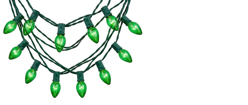 Festive glowing green Christmas string lights with classic bulbs and wires, decorative holiday illumination for St Patrick's Day or seasonal celebrations, isolated on white background.