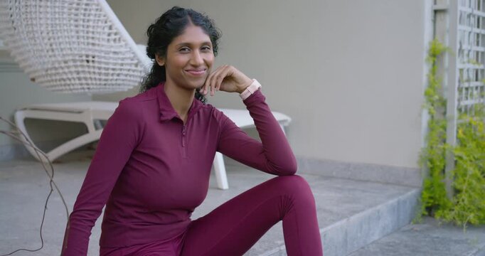African American woman on concrete steps, smiling, laughing as camera moving closer showing watch