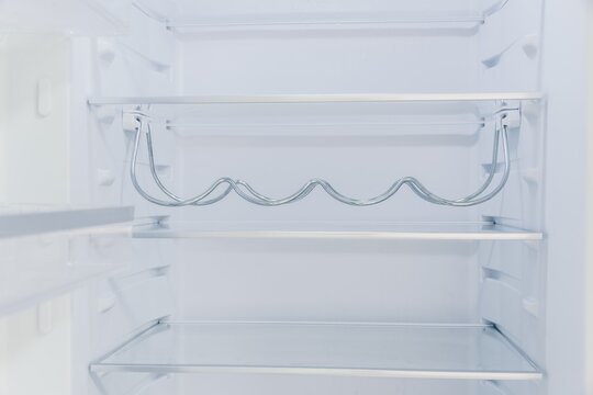 Refrigerator interior shelves with wire rack design and clear glass surfaces highlighting storage...