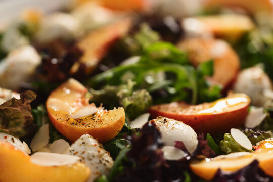 Closeup salad with nectarines, mozzarella and mixed greens