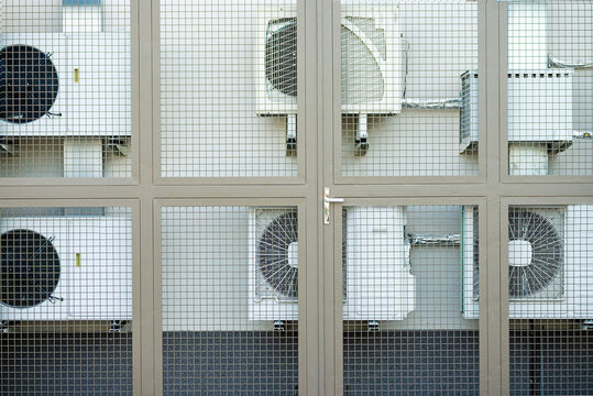 Row of modern outdoor air conditioner units installed on a building facade