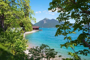 view to green trees to turquoise lake Walchensee with boathouse and Jochberg mountain © SusaZoom