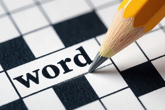 Close up of yellow pencil writing on crossword puzzle paper. Hand completes word in game grid. Person solves brain teaser for fun education. Hobby activity involves thinking skill, vocabulary test