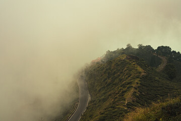 Scenic hill station landscape in India with green mountains, misty valleys and forest. Beautiful Himalayan scenery, ideal for travel, tourism, nature and holiday destination themes. © Sanket Mishra
