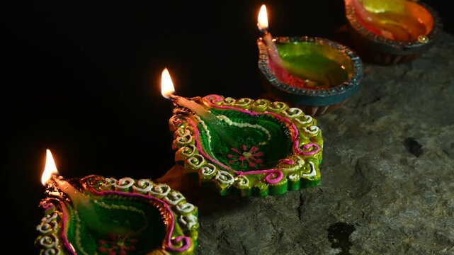 happy diwali many terracotta diya or oil lamps arranged over clay surface or ground in one line or curved or zigzag form