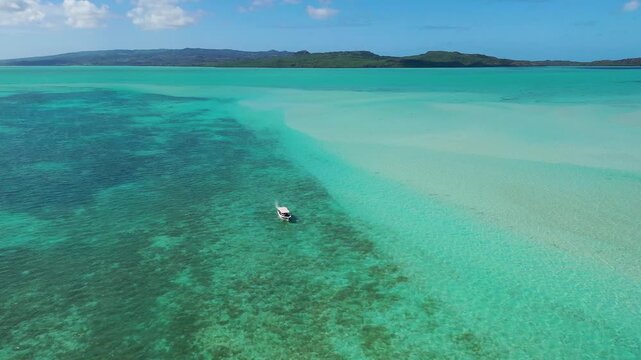 Small boat cruising over shallow sea in Indian Ocean