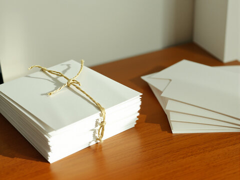 Stack of plain white cards tied with twine on a wooden desk