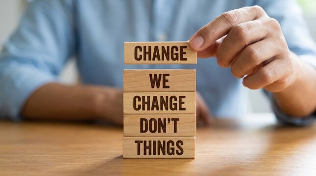 Hands building blocks with the words change we change dont things
