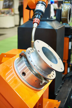 Robotic Welding Torch Positioned Over a Flanged Metal Pipe