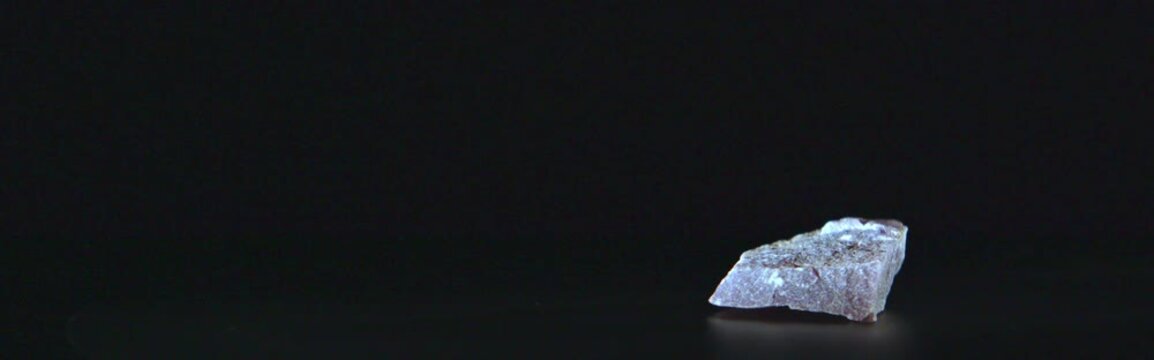 Purple lepidolite mineral rotating on black background