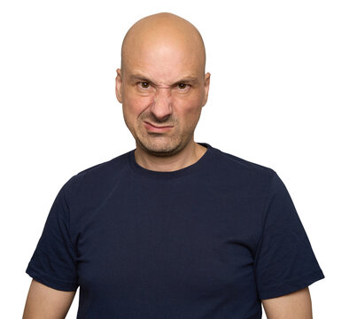 Serious bald man in dark blue t-shirt looking displeased