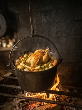 Poule au pot sur feu de bois dans chemin&eacute;e 