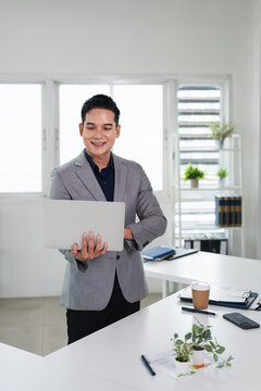 Businessman using laptop computer in office. Happy middle aged man, entrepreneur, small business owner working online.