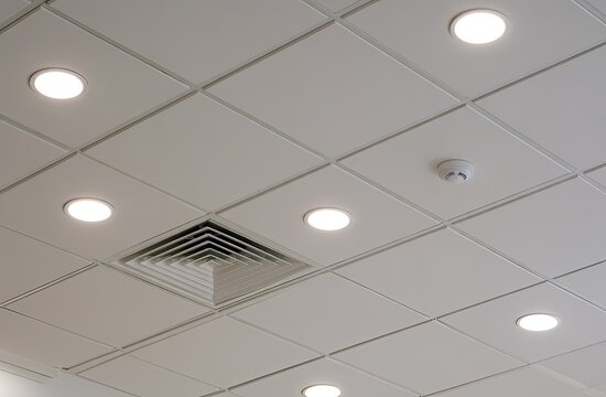 A white, square-tiled ceiling with recessed lights and a ventilation vent