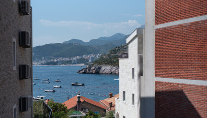 Scenic view of boats anchored in a blue bay on the Adriatic Sea, framed by coastal buildings in Montenegro © Denis Renkas