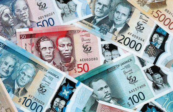 Jamaican dollar money banknotes pile on table. Jamaica bills of JMD currency close up