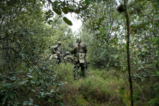 Airsoft fire team moving through the trees during a twenty four hour war game near Carcassonne, France