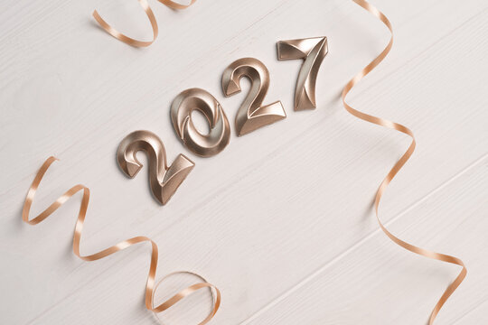 Golden numbers 2027 and decorative ribbons creating a cheerful festive events atmosphere for upcoming