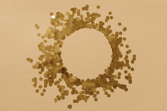Golden glitter forming a sparkling circular frame providing elegant copy space for festive or celebratory design