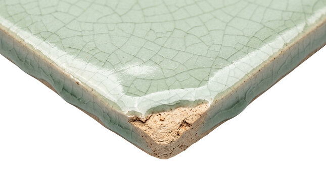 Vintage light green ceramic crackle tile corner detail, glossy celadon porcelain surface sample, chipped pottery edge close up