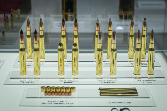 Large calibre ammunition rounds lined up behind glass at a defence trade fair near Paris, France