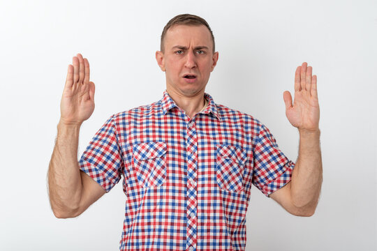 Man raising both hands with palms open, signaling to stop or reject something, displaying a facial expression of strong disapproval, discomfort, and disgust
