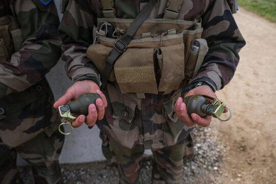 Foreign Legion recruit holding two grenades in his hands during basic training in France